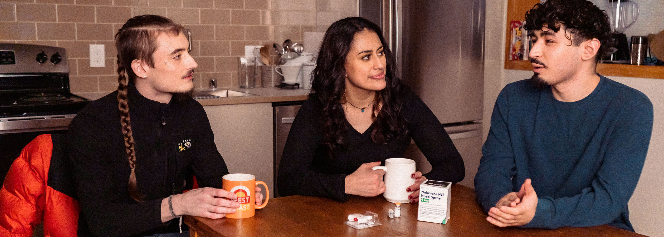 Young adults sitting at a table, talking.
